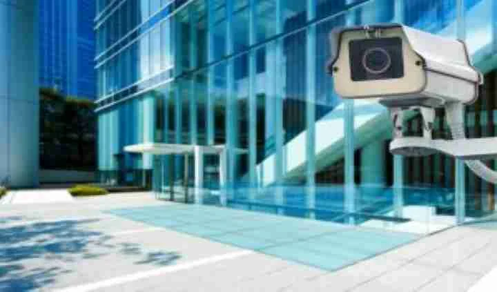 Security camera outside a modern glass-fronted commercial building