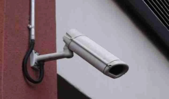 Bullet security camera mounted beside a residential wall
