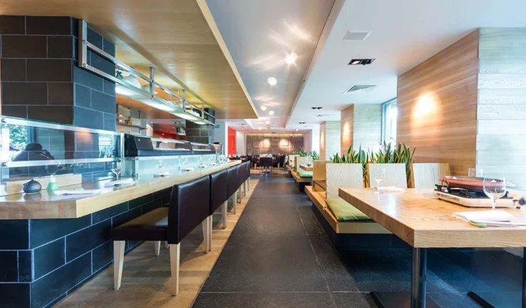 Restaurant interior with booths, tables and an open kitchen