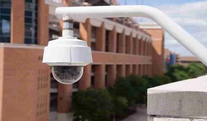Dome security camera overlooking a school building