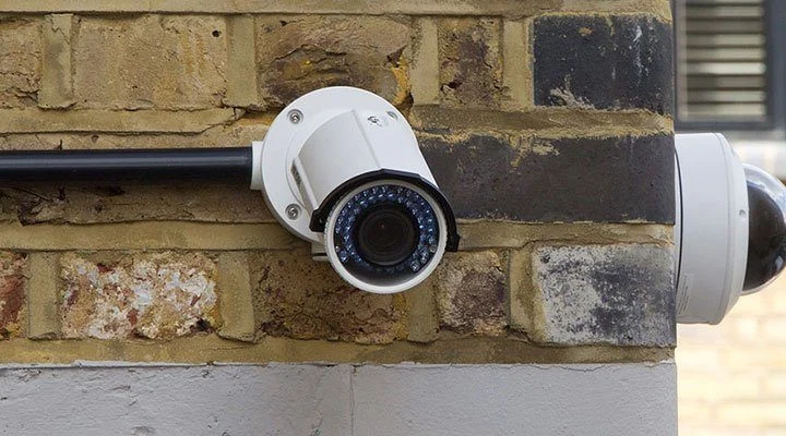 Turret security camera mounted on the corner of a brick wall