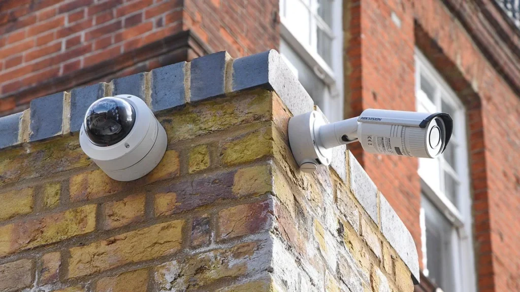 Dome and bullet security cameras on the corner of a brick building