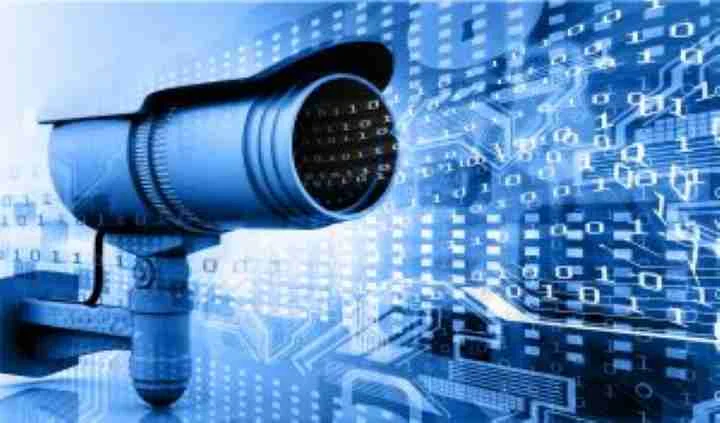 Security camera against a blue digital data background